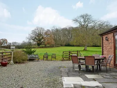 a patio with a table and chairs and a field at Howards End in Middleton on the Hill