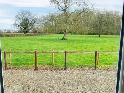 a fence in front of a field of green grass at Howards End in Middleton on the Hill