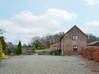 a brick house on a gravel driveway at Howards End in Middleton on the Hill