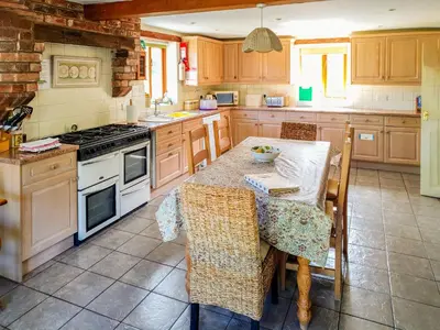 a kitchen with a table and a stove top oven at Howards End in Middleton on the Hill