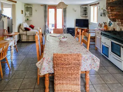 a kitchen with a table with chairs and a dining room at Howards End in Middleton on the Hill