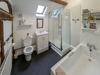 a bathroom with a toilet and a shower and a tub at Howards End in Middleton on the Hill