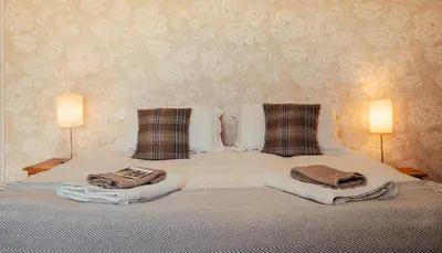 a bed with towels and pillows on it with two lamps at Stone House Wales in Kington