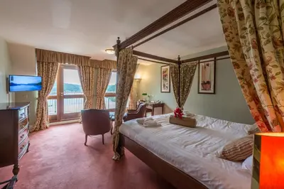 a bedroom with a bed and a large window at Lake Vyrnwy Hotel & Spa in Llanwddyn