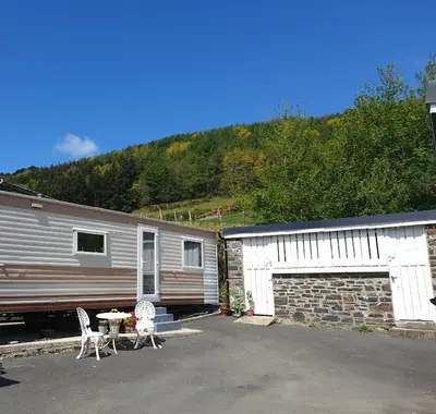 a house with a trailer and a table and chairs next to a train at Ideal rural location for beaches, hills and town in Bow Street