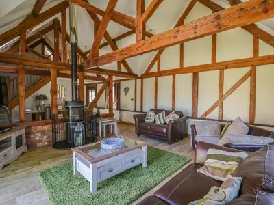 a large living room with wooden ceilings and wooden beams at Awelfan in Newtown