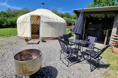 a tent with a table and chairs in front of it at Bronfelen Yurt in Cynghordy
