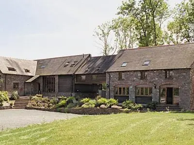 a large brick house with a lawn in front of it at The Bailey in Glasbury