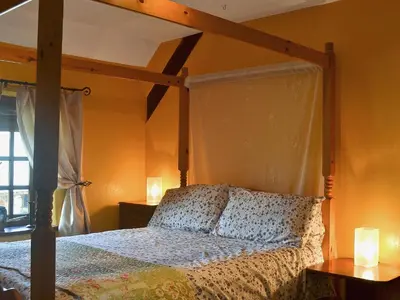 a bedroom with a canopy bed with two candles at The Bailey in Glasbury