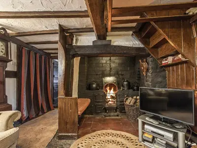 a living room with a fireplace and a television at Pen Copi in Trefeglwys
