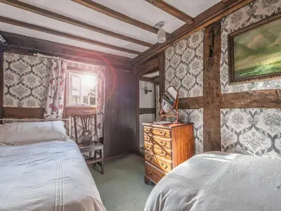 a bedroom with two beds and a dresser in it at Pen Copi in Trefeglwys