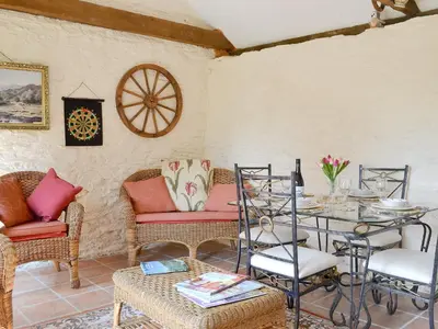 a living room with a table and chairs and a table at Forget Me Not Cottage in New Radnor