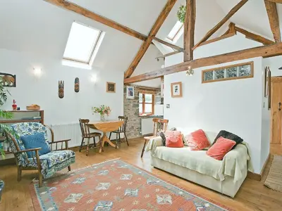 a living room with a couch and a table at Llofft Stabal in Llanerfyl