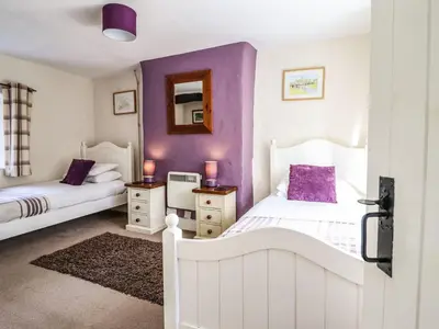 a bedroom with two beds and purple walls at Pen y Bont in Machynlleth