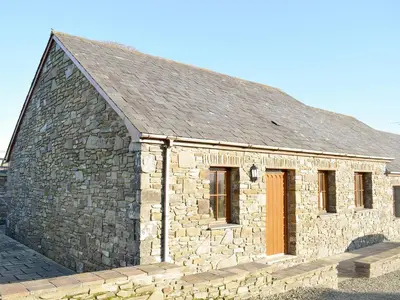 an old stone building with a stone wall at Tan-Y-Derwwen in Mydroilin