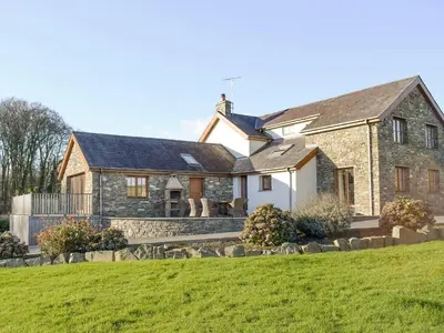 a large stone house with a green lawn at The Farmhouse in Mydroilin