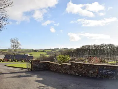 a stone retaining wall with a gate on a road at The Farmhouse in Mydroilin