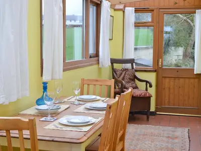 a dining room with a wooden table and chairs at Panteg Cottage in Cross Inn