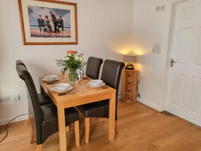a dining room with a wooden table and black chairs at Bwthyn Gwyn in Ciliau-Aeron