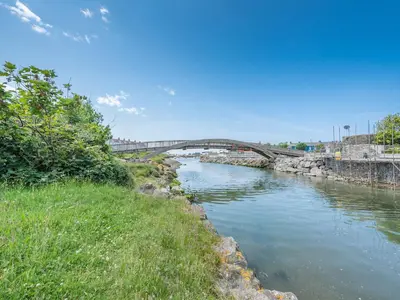 a river with a bridge in the background at Glendower in Aberaeron