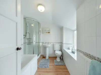 a white bathroom with a toilet and a sink at Glendower in Aberaeron