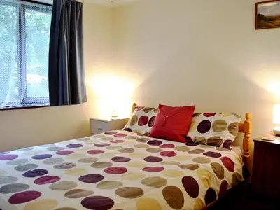 a bedroom with a bed with a polka dot blanket at Greenmeadow Bungalow in Llanon