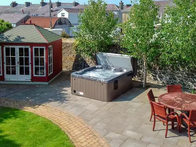 a hot tub sitting on a patio with a table at Awelfa - On7 in Aberaeron