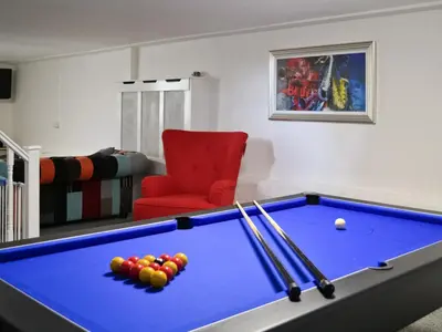 a living room with a pool table and a red chair at Awelfa - On7 in Aberaeron