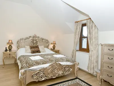 a bedroom with a bed and a dresser and a window at Magnolia Cottage in Aberaeron