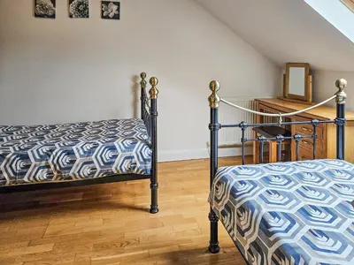 a bedroom with a bed and a wooden floor at Cartws-Oh3 in Dihewid