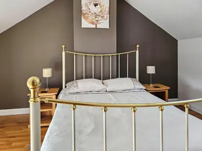 a bedroom with a bed with a metal frame at Stabl-Oh4 in Dihewid