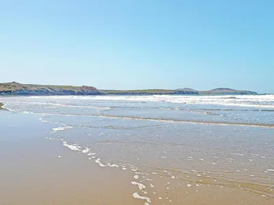 a beach with waves coming in from the ocean at Stabl-Oh4 in Dihewid