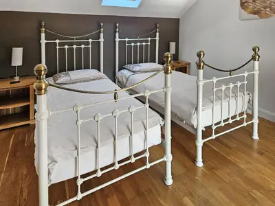 two metal beds in a bedroom with wood floors at Stabl-Oh4 in Dihewid