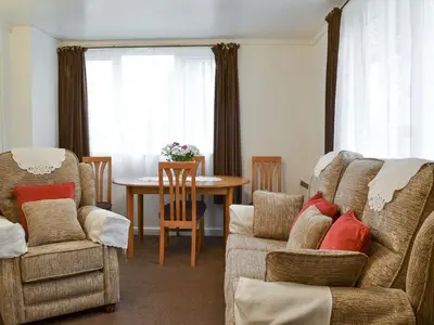 a living room with a couch and chairs and a table at Tynlon Villa in Bronant