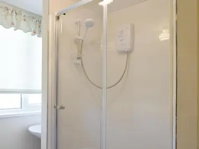 a shower in a bathroom with a glass door at Tynlon Villa in Bronant