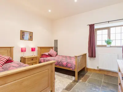 a bedroom with two beds and a window at Yr Hen Stabl in Tregaron