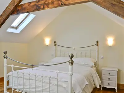 a bedroom with a white bed and a skylight at Felin Hedd Peaceful Mill in Tregaron
