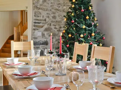 a dining room table with a christmas tree in the background at Felin Hedd Peaceful Mill in Tregaron