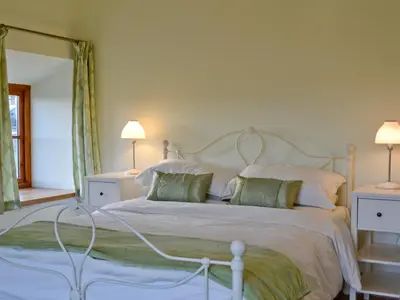 a bedroom with a white bed with green pillows at Felin Hedd Peaceful Mill in Tregaron