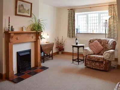 a living room with a fireplace and a chair at Marlais in Llangadog