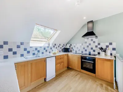 a kitchen with wooden cabinets and a sink and a window at Field View in Cynghordy