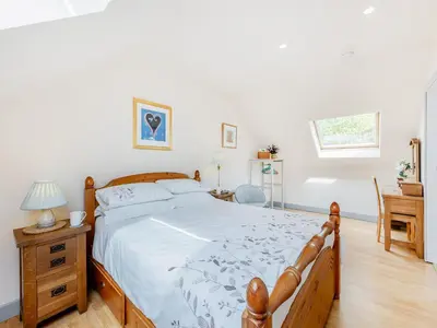 a bedroom with a large bed and a desk at Field View in Cynghordy
