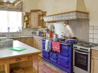 a kitchen with a blue stove top oven at Crogen Coach House - Oqr in Llandrillo