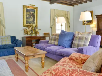 a living room with purple couches and a table at Crogen Coach House - Oqr in Llandrillo
