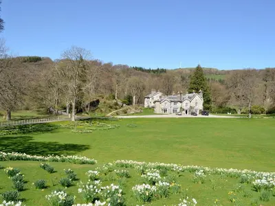 a large grassy field with a house in the background at Crogen Wing in Llandrillo