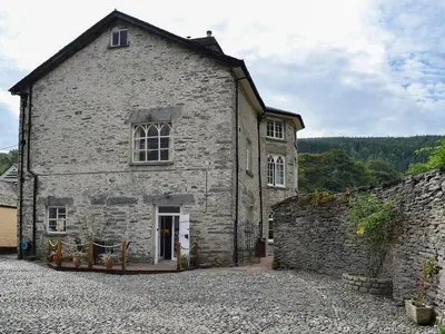 an old stone building with a stone wall at Crogen Wing in Llandrillo