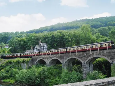 a train on a bridge with a house on it at Hen Hafod in Llanfor