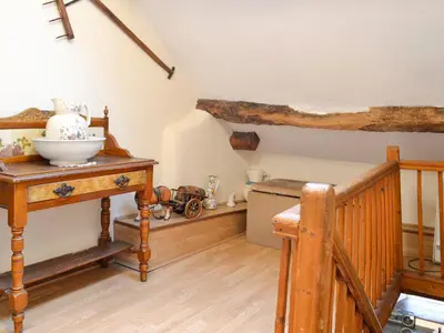 a room with a staircase and a table with a bowl on it at Hen Hafod in Llanfor