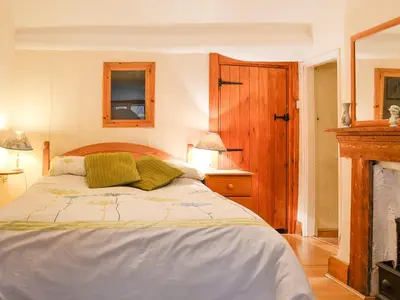 a bedroom with a bed and a fire place at Hen Hafod in Llanfor