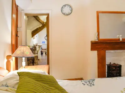 a bedroom with a bed and a mirror and a clock at Hen Hafod in Llanfor